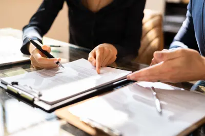 Two Businesspeople Working On Contract Paper