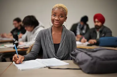 A student is taking notes in a classroom