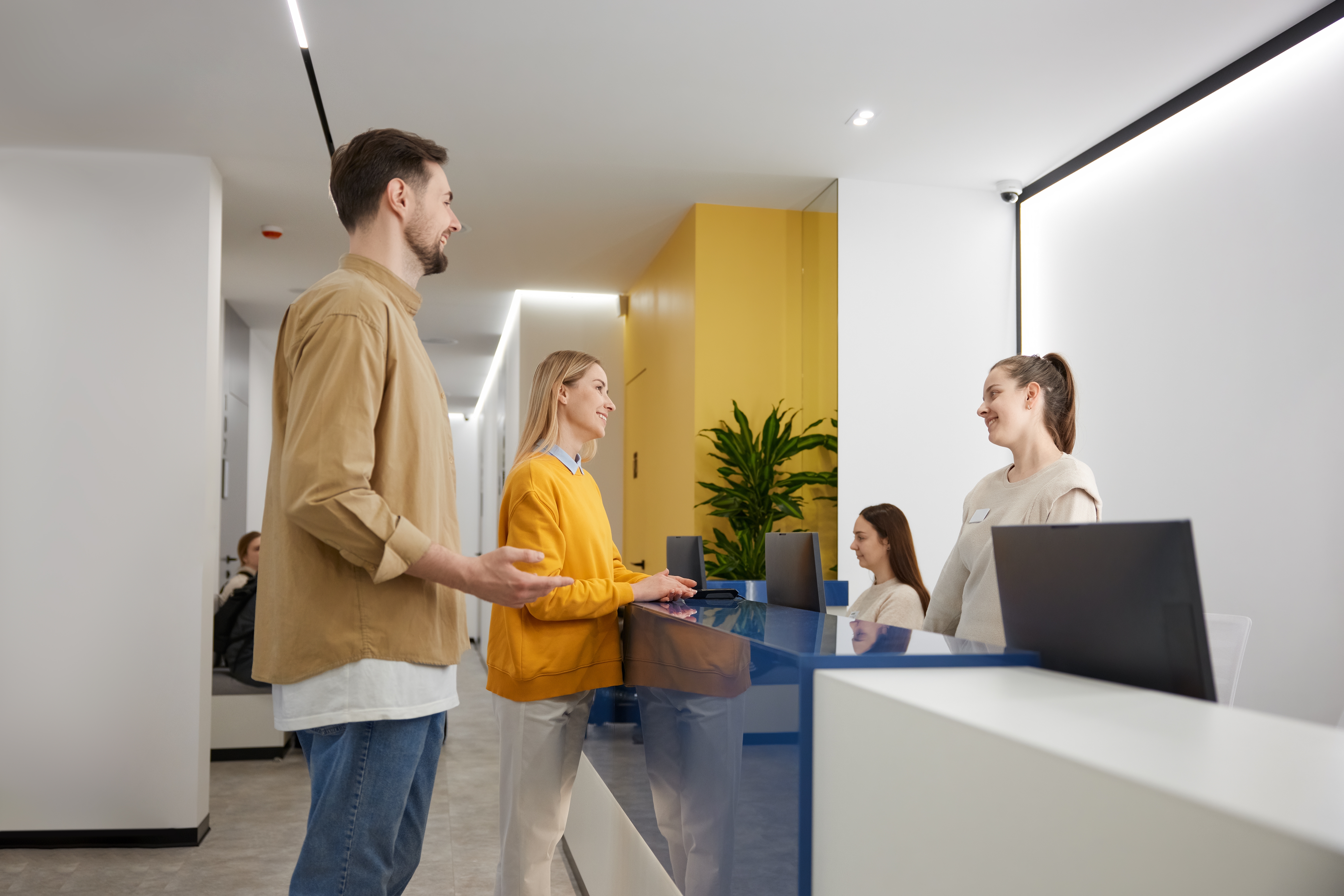 Man and woman couple talking to receptionist at family clinic center