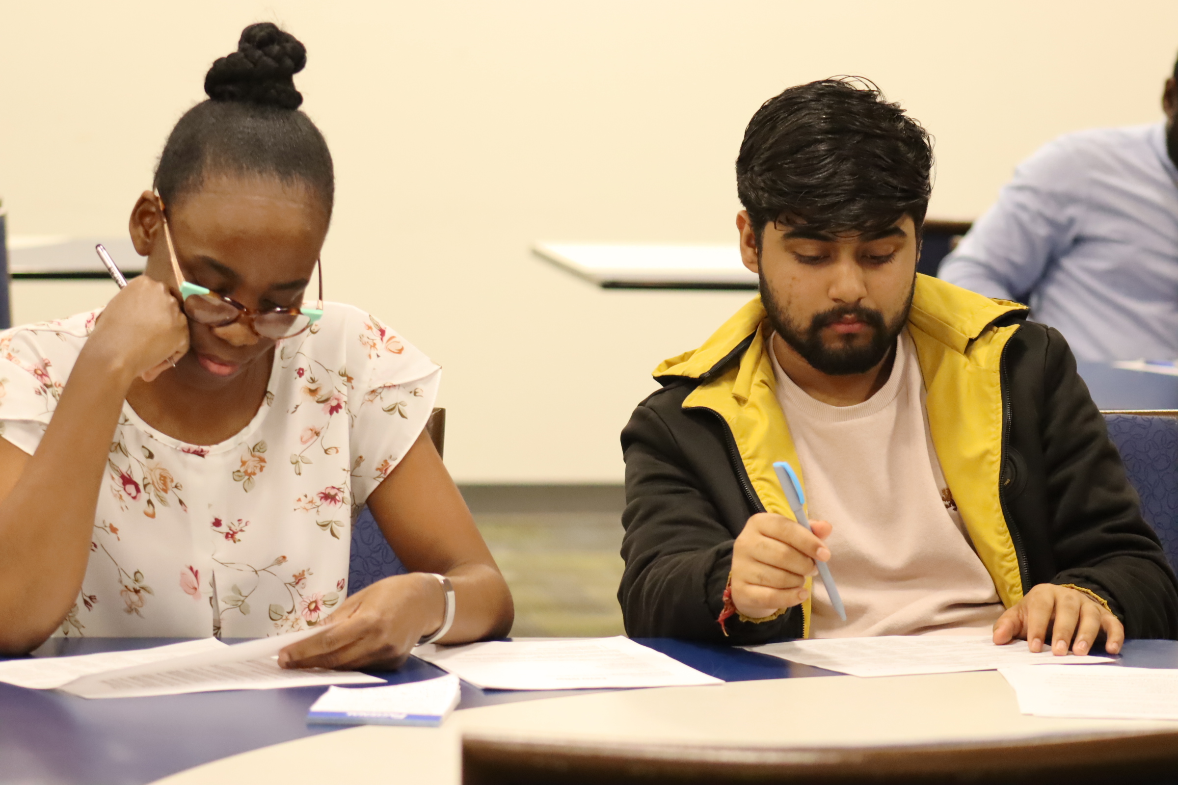 Two students taking notes in class